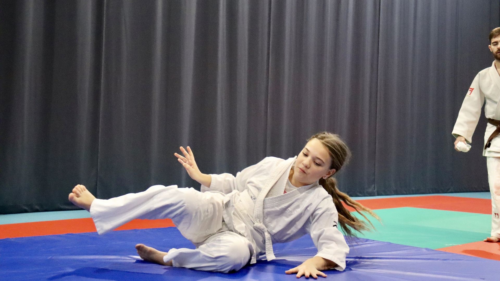 Une judoka termine une chute sur le tatami du dojo de Cuvry
